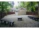 Backyard with gravel area, fire pit, benches, wooden fence, and view of the house and garage at 536 Moreland Ne Ave, Atlanta, GA 30307