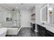 Luxurious bathroom with soaking tub, glass shower, and dark tile floors at 2626 Sardis Way, Buford, GA 30519