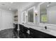 Spa-like bathroom with double vanities, backlit mirrors, and dark cabinetry at 2626 Sardis Way, Buford, GA 30519