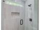 Walk-in shower with gray tile and built-in shelf at 2626 Sardis Way, Buford, GA 30519