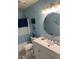 Bathroom with white vanity, round mirror, and blue walls at 2705 Greystone Pl, Austell, GA 30106