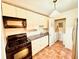 Galley kitchen with white cabinets, black appliances, and tile floor at 2705 Greystone Pl, Austell, GA 30106