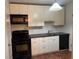 Kitchen with white cabinets, black appliances, and tile floor at 2705 Greystone Pl, Austell, GA 30106