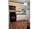 Compact kitchen with white cabinets, black appliances, and tiled floor at 2705 Greystone Pl, Austell, GA 30106