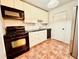 Galley kitchen with white cabinets, black appliances, and tile floor at 2705 Greystone Pl, Austell, GA 30106