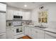 Modern white kitchen with stainless steel appliances, marble countertops, and white cabinetry at 370 Charlyne Way, Dacula, GA 30019