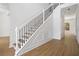 Elegant staircase with wrought iron balusters and hardwood flooring at 5720 Vickery Cir, Cumming, GA 30040