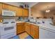 Galley kitchen with oak cabinets, white appliances, and ample counter space at 2031 Austin Park Cir, Decatur, GA 30032