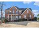 Brick two-story house with a large front yard and manicured landscaping at 2612 Grove Park Ln, Conyers, GA 30094