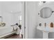 Small bathroom with pedestal sink and round mirror at 966 Moda Dr, Atlanta, GA 30316