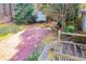 View of backyard brick patio, wooden deck, storage shed, and trees at 315 Orchard Dr, Temple, GA 30179