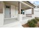 Front porch with gray door, wooden posts, and white brick exterior at 227 Wild Ginger Bnd, Woodstock, GA 30188