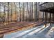 Wooded backyard with a concrete patio, wooden deck, and split-rail fence at 514 Lovinggood Ct, Woodstock, GA 30189