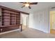Bedroom with built-in bookshelf, ceiling fan, closet, and neutral carpet at 6851 Roswell Rd # D14, Atlanta, GA 30328
