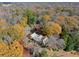 Another aerial view of the property among the autumn trees and outbuildings at 7865 Nesbit Ferry Rd, Sandy Springs, GA 30350