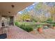 Relaxing backyard with a pond, lush foliage, rocking chairs, and a brick patio at 7865 Nesbit Ferry Rd, Sandy Springs, GA 30350