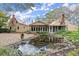 Backyard with a pond, screened porch, and lush landscaping at 7865 Nesbit Ferry Rd, Sandy Springs, GA 30350