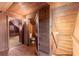 Bathroom with wood-paneled walls, exposed beams, and a toilet tucked behind a small door at 7865 Nesbit Ferry Rd, Sandy Springs, GA 30350
