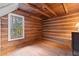 Cozy bedroom with wood-paneled walls, hardwood floors, and a large window at 7865 Nesbit Ferry Rd, Sandy Springs, GA 30350
