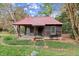 Charming log cabin with a red metal roof, porch, and swing at 7865 Nesbit Ferry Rd, Sandy Springs, GA 30350