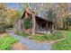 Quaint log cabin nestled in a wooded setting with a gravel pathway at 7865 Nesbit Ferry Rd, Sandy Springs, GA 30350