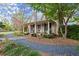 Front view of a charming home with a large porch and rocking chairs at 7865 Nesbit Ferry Rd, Sandy Springs, GA 30350