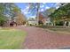 Charming two-story home with a brick driveway and lush landscaping at 7865 Nesbit Ferry Rd, Sandy Springs, GA 30350