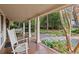 Relaxing front porch with rocking chairs and a swing overlooking the yard at 7865 Nesbit Ferry Rd, Sandy Springs, GA 30350