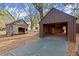 Detached garage and shed in a backyard with trees and fallen leaves at 7865 Nesbit Ferry Rd, Sandy Springs, GA 30350