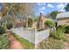 View of the garden with a white picket fence, stone pathway, trees, and various plants at 7865 Nesbit Ferry Rd, Sandy Springs, GA 30350