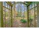 Wooden arbor gateway to a peaceful garden path surrounded by trees at 7865 Nesbit Ferry Rd, Sandy Springs, GA 30350