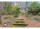 Stone path leads through a tranquil garden setting with a wooden archway at 7865 Nesbit Ferry Rd, Sandy Springs, GA 30350