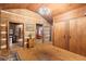 Rustic hallway with wood floors, exposed log walls, and access to other rooms at 7865 Nesbit Ferry Rd, Sandy Springs, GA 30350