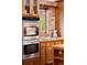 Kitchen with double oven, exposed brick wall, and cooktop at 7865 Nesbit Ferry Rd, Sandy Springs, GA 30350