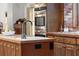 Kitchen island with sink, pendant lighting, and wood cabinets at 7865 Nesbit Ferry Rd, Sandy Springs, GA 30350