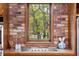 Kitchen features brick wall, cooktop, and window at 7865 Nesbit Ferry Rd, Sandy Springs, GA 30350
