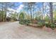 Gravel driveway leading to a fenced area with various plants and landscaping materials at 7865 Nesbit Ferry Rd, Sandy Springs, GA 30350
