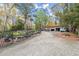 Outbuilding with garage doors, parking area, and landscaping supplies at 7865 Nesbit Ferry Rd, Sandy Springs, GA 30350