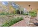 Brick patio with rocking chairs overlooking a serene pond and landscaped backyard at 7865 Nesbit Ferry Rd, Sandy Springs, GA 30350