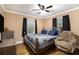 Large bedroom with wood floors, ceiling fan, and plush recliner at 8451 Duncan St, Douglasville, GA 30134