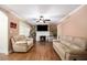 Living room with hardwood floors, a fireplace, two sofas, and a ceiling fan at 8451 Duncan St, Douglasville, GA 30134