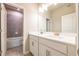Modern bathroom featuring white double vanity, neutral tiled shower, and updated hardware at 7640 Homer Dr, Cumming, GA 30028