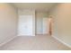 Unfurnished bedroom featuring carpet, double closet doors, and an open door leading to another room at 7640 Homer Dr, Cumming, GA 30028