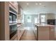 Bright, open kitchen with white cabinets, stainless steel appliances, and an island with sink at 7640 Homer Dr, Cumming, GA 30028