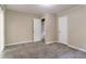 Empty bedroom featuring neutral walls, plush carpeting, and an open doorway at 633 Larchmont Nw Cir, Atlanta, GA 30318