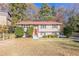 Two-story home with red door, shrubs, and green lawn at 633 Larchmont Nw Cir, Atlanta, GA 30318