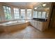 Spacious bathroom with jacuzzi tub, large vanity, and tile flooring at 1378 Wesley Oaks Nw Ct, Atlanta, GA 30327