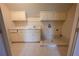 Laundry room with white cabinets, sink, and tiled floor at 1378 Wesley Oaks Nw Ct, Atlanta, GA 30327