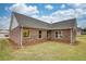 Rear view of a home with brick exterior and green lawn at 711 Park Place Way, Social Circle, GA 30025