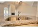 Granite countertop with stainless steel double sink and modern faucet in a spacious kitchen at 711 Park Place Way, Social Circle, GA 30025